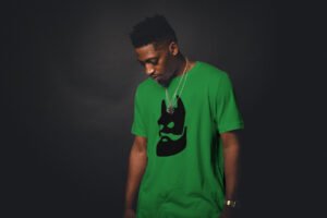 man wearing green tee shirt with jason kelce in a batman mask