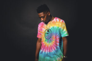man wearing tie dye colored shirt with stay rad artwork