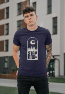 man wearing blue tee shirt that says stay rad in front of building
